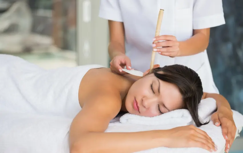 Woman lying face down and undergoing ear candling
