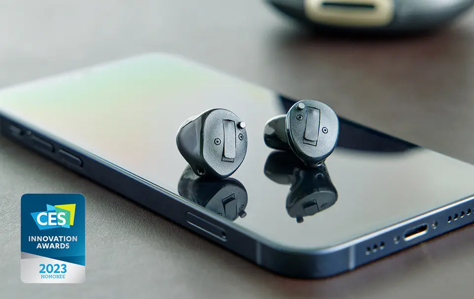 Pair of custom hearing aids placed on top of a mobile phone