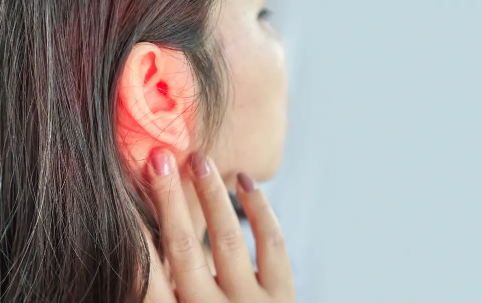 Lady touching the back of her ear
